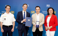 Das Foto zeigt: Regierungspräsident Rainer Haselbeck bei der Aushändigung der Christophorus-Medaille an Julian Bräuer. Mit ihrem Kommen zollten auch Niederbayerns Polizeipräsident Roland Kerscher und Landshuts Dritte Bürgermeisterin Jutta Widmann dem Lebensretter Dank und Anerkennung